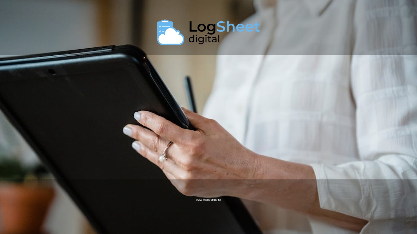 Close-up of a woman holding a digital tablet in an office environment, focusing on hand details.
