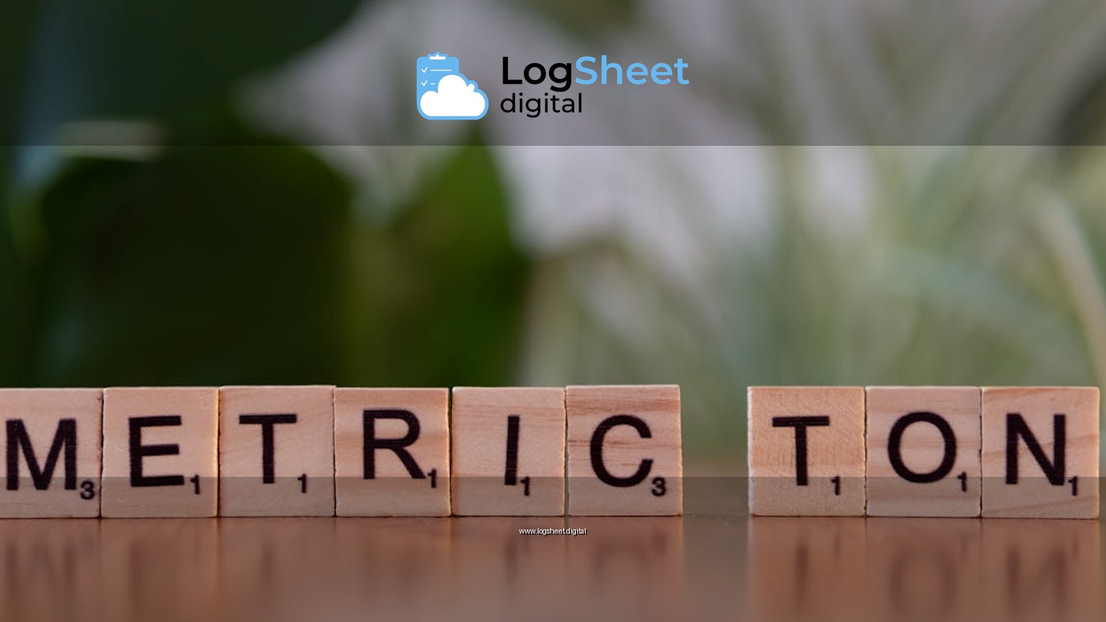 Scrabble tiles on a brown surface spell 'Metric Ton' with blurred green background.