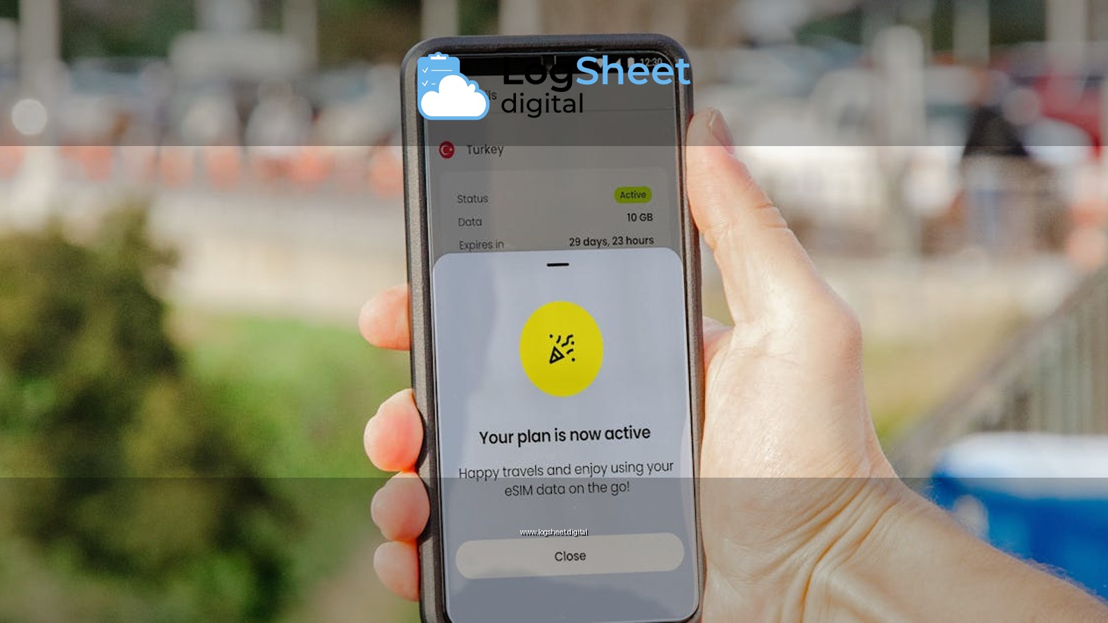 Smartphone showing active eSIM plan held outdoors, blurred city background.