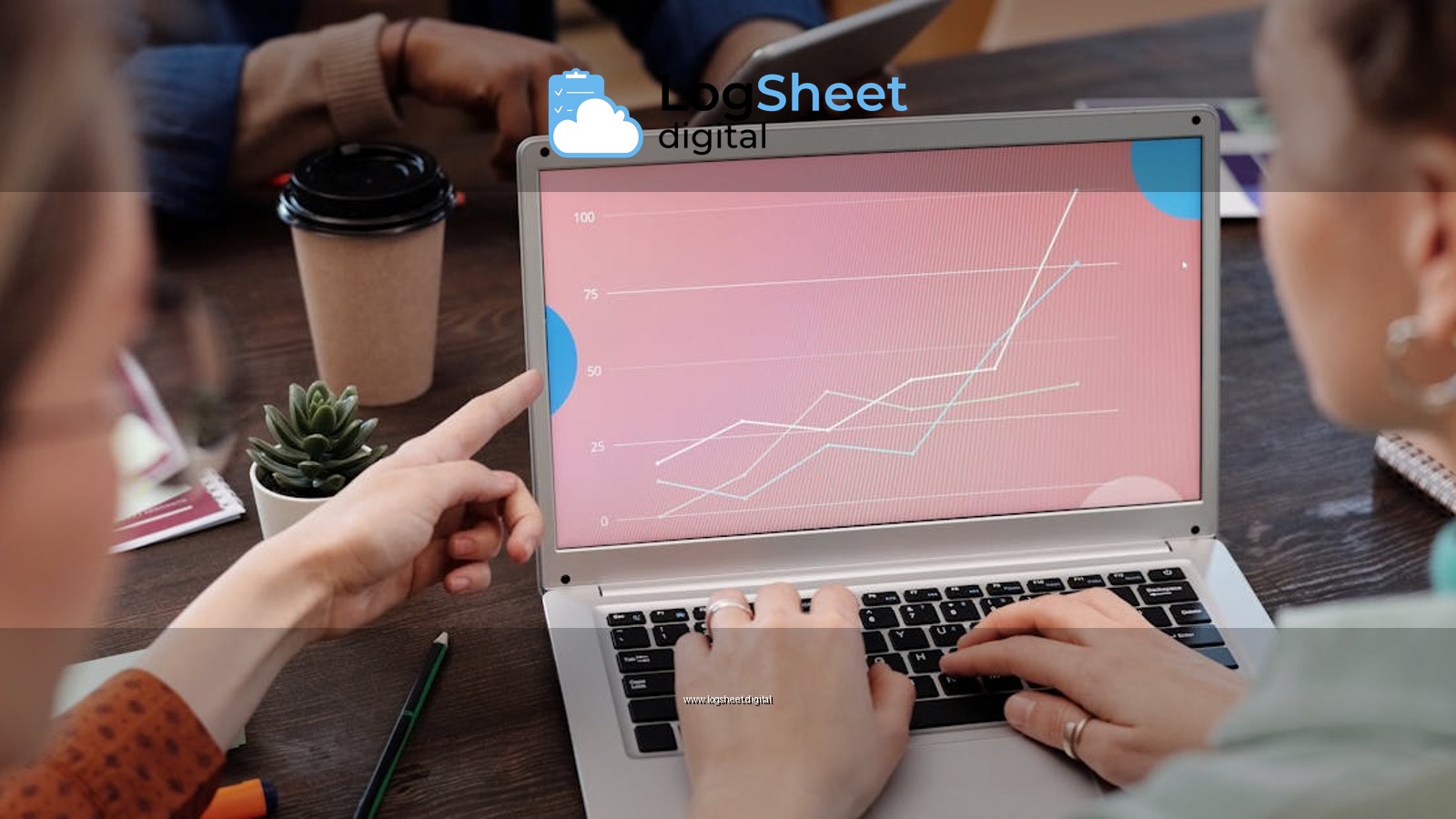 Office workers collaboratively reviewing data trends on a laptop during a meeting.