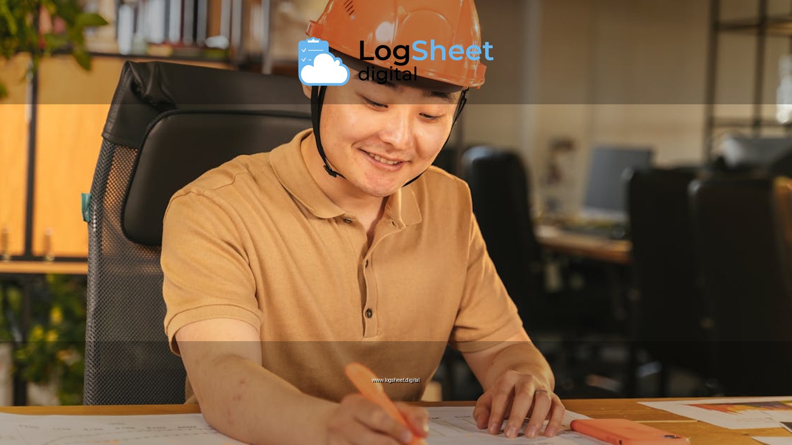 Smiling engineer in hard hat studies blueprints at an office desk, highlighting construction and planning.
