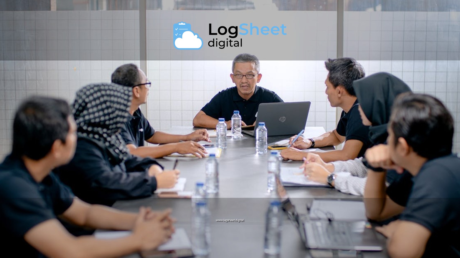 Professional team meeting around a conference table in an office setting.