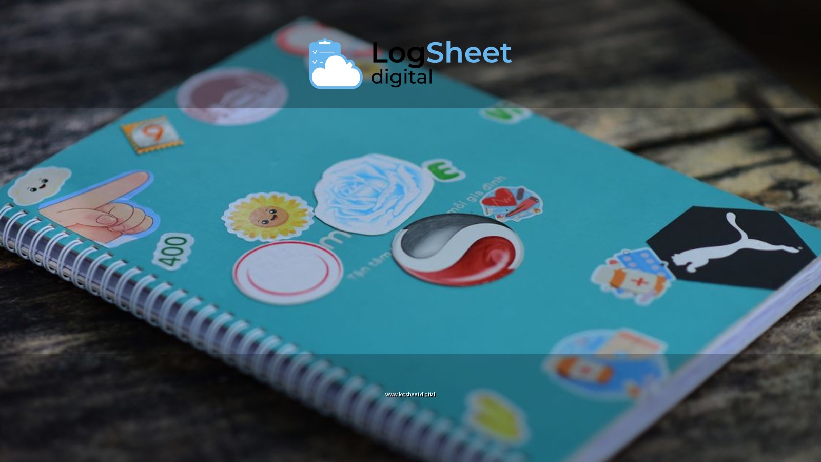 A blue spiral notebook adorned with colorful stickers on a rustic wooden surface.