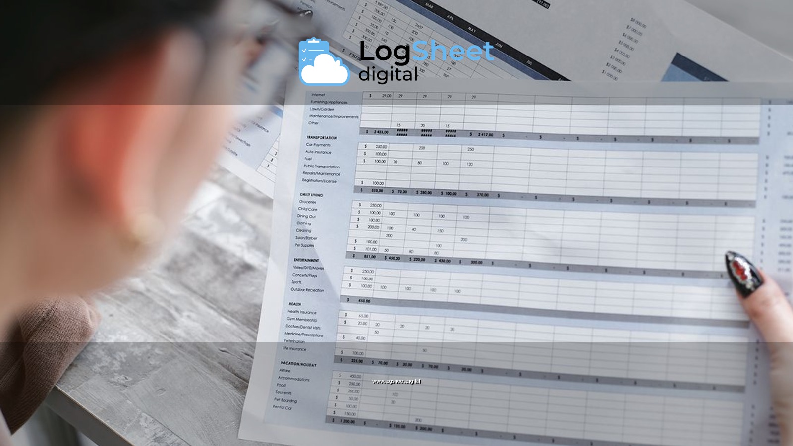 A businesswoman reviewing financial spreadsheets with charts and graphs in an office setting.