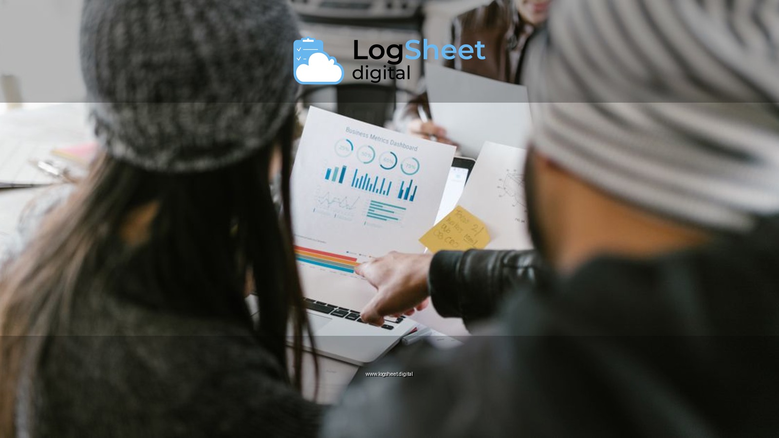 Team members discussing business metrics using printed charts in a cozy meeting space.