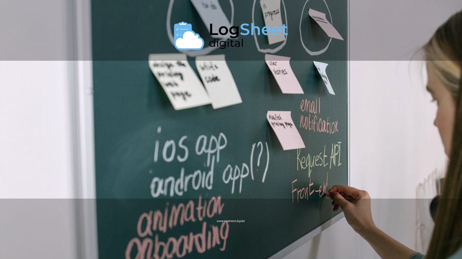 Woman writing on chalkboard during a brainstorming session in an office setting.