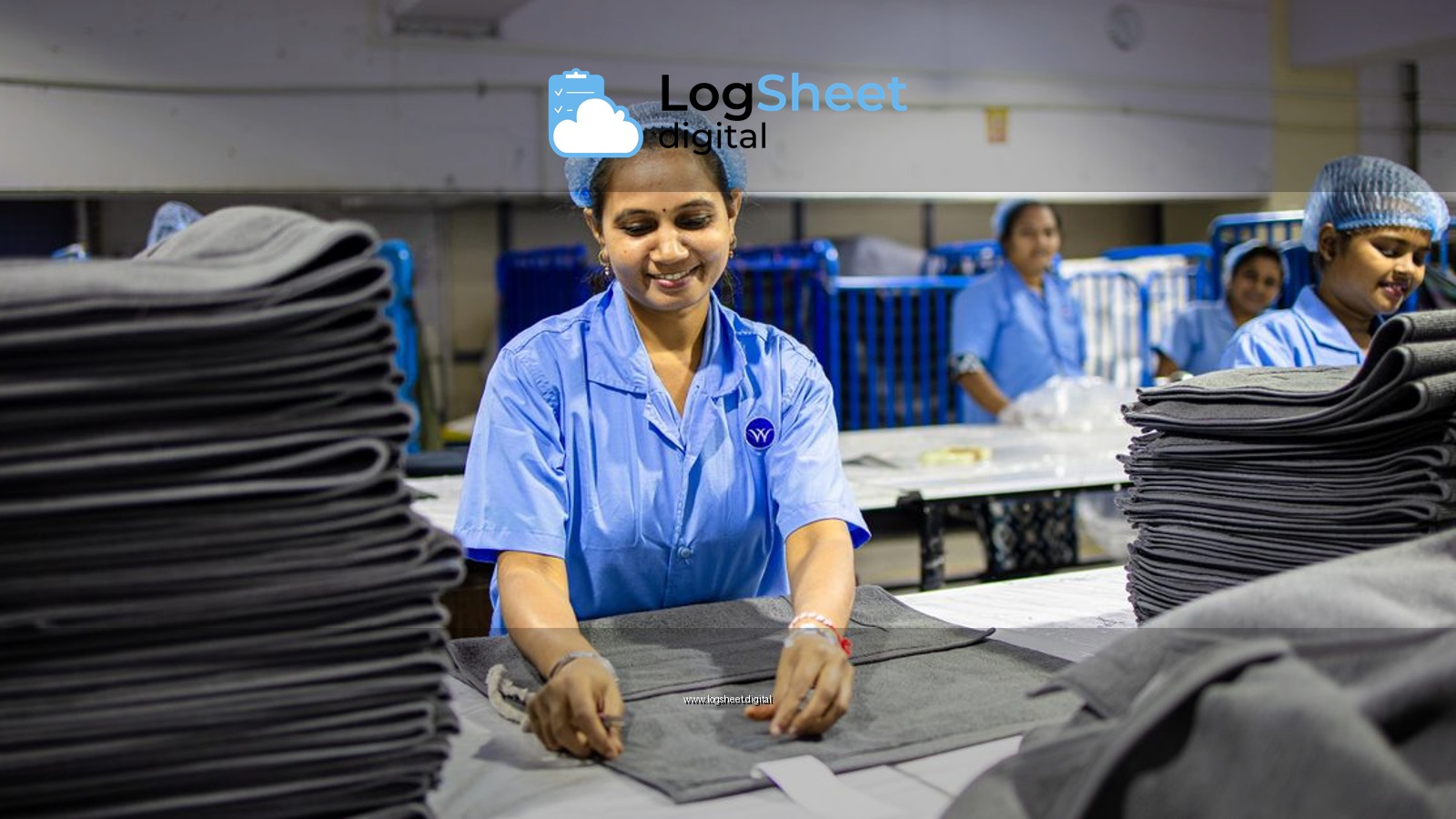 Female workers in textile factory, folding grey fabric. Industrial setting.