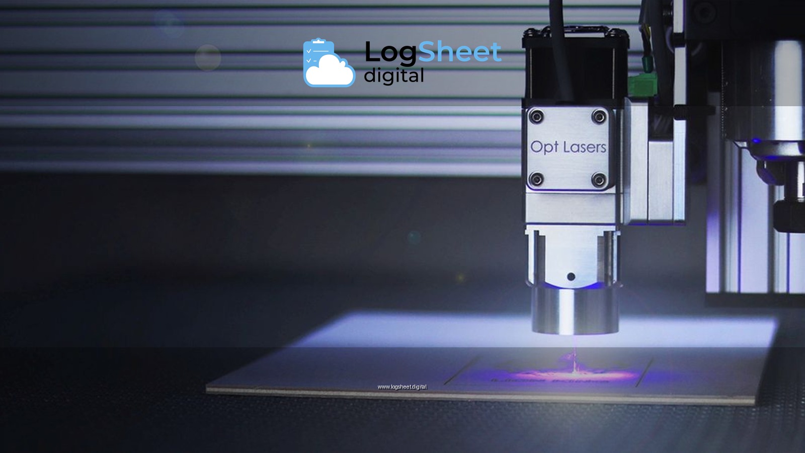 Close-up of a laser engraver working on a surface under blue lighting.