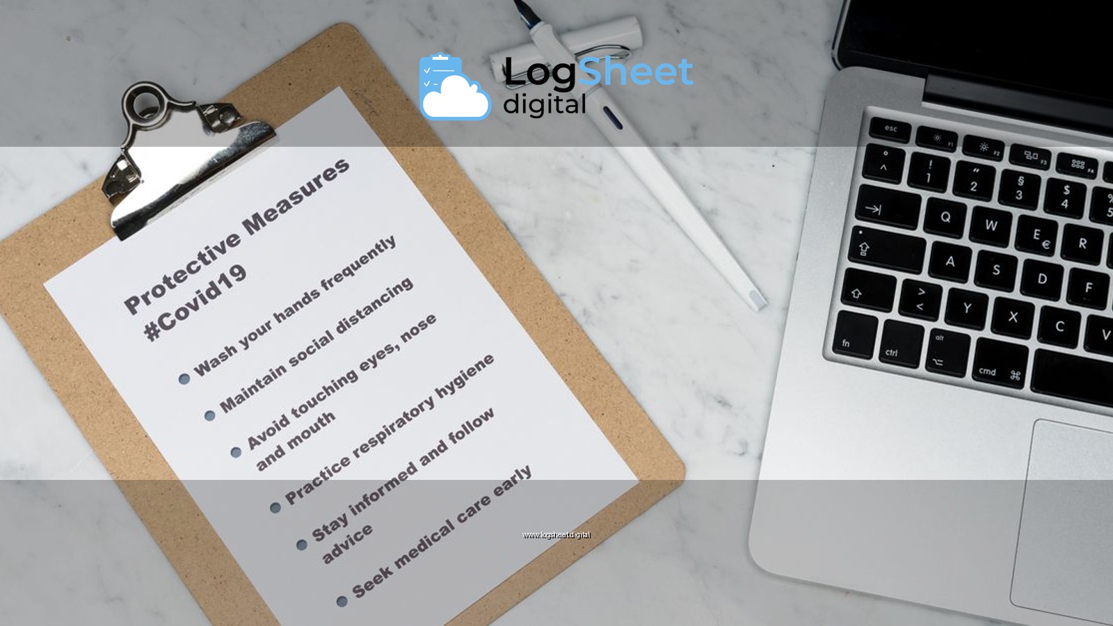 Flat lay of a clipboard listing Covid-19 safety measures beside a laptop on a marble surface.