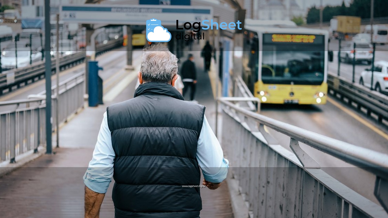 A man walks towards an approaching bus at a city bus station, depicting urban commuting.